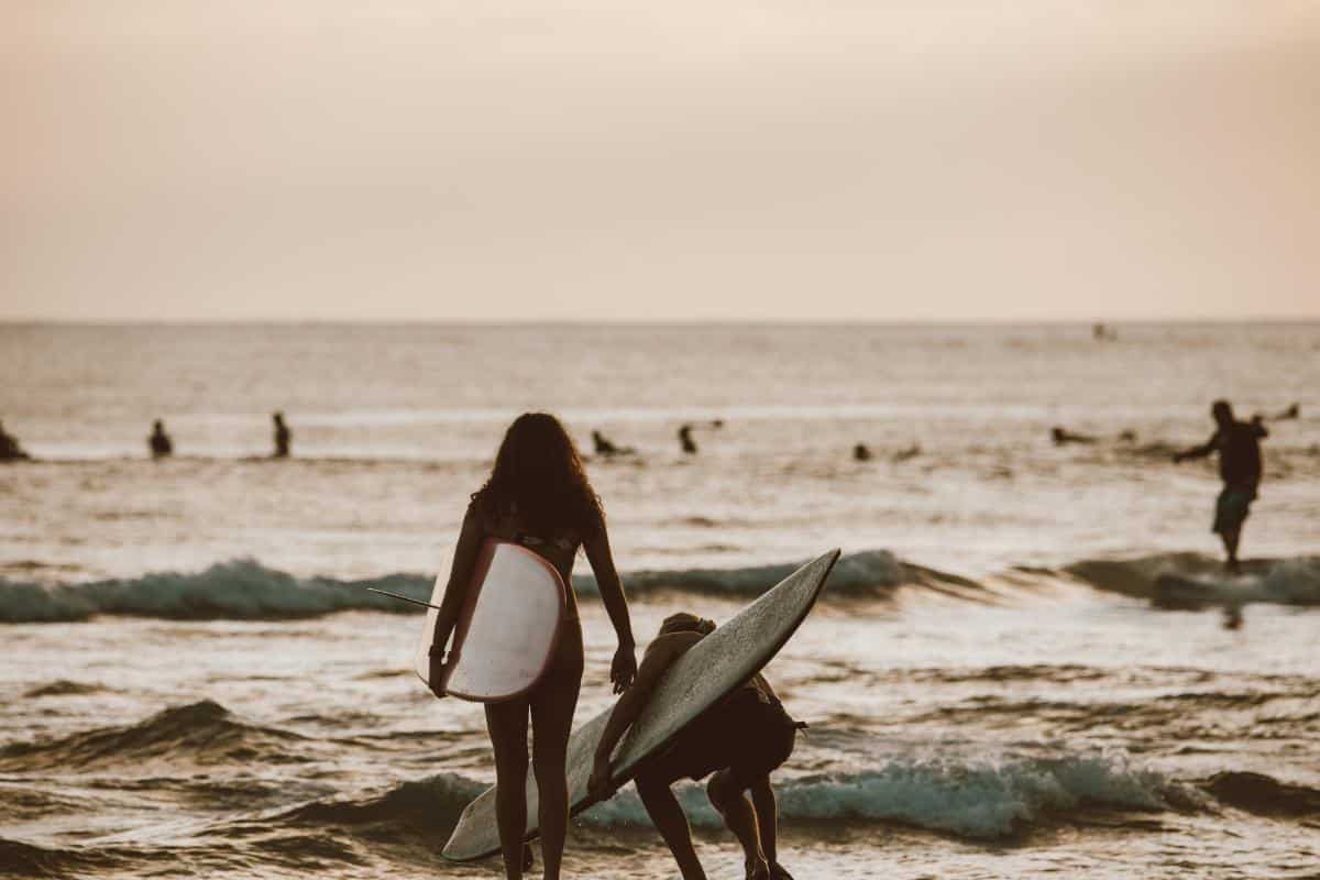 a couple of people on a beach next to the ocean