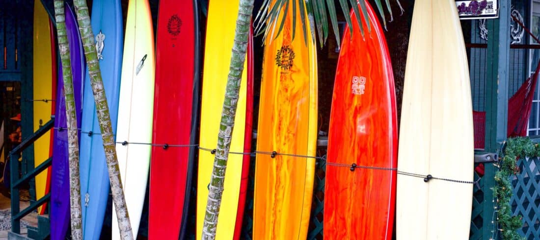 a group of people standing on top of a surfboard