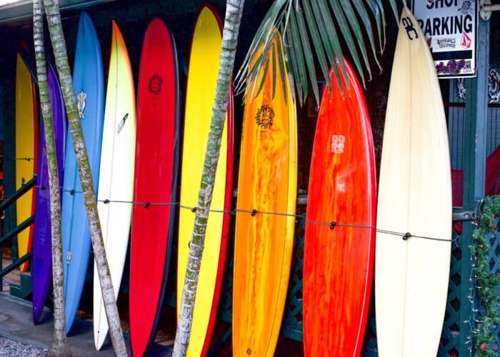 a group of people standing on top of a surfboard