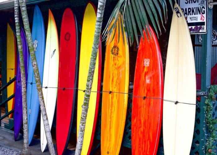 a group of people standing on top of a surfboard