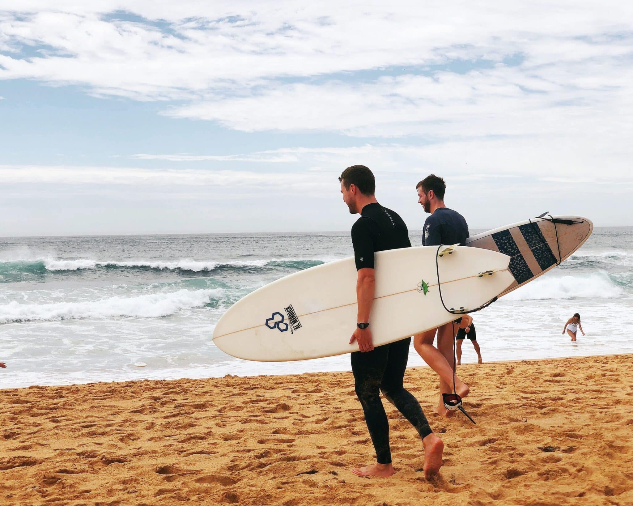 a man carrying a surf board walking on a beach